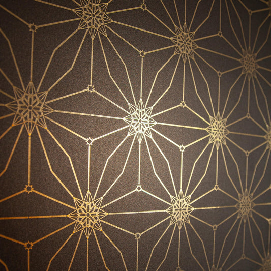 Star Guitar Night is a shimmering repeat moroccan inspired pattern and star motif linked together with a graphic thread in black digitally printed on gold mylar  - shown at an angle with the light catching off the gold