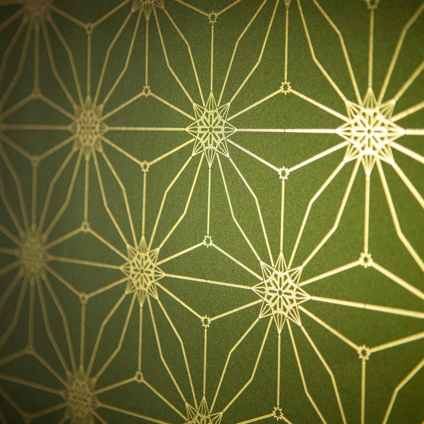 Star Guitar Magic Hour is a shimmering repeat moroccan inspired pattern and star motif linked together with a graphic thread in metallic green digitally printed on gold mylar - shown at an angel with the light bouncing off the gold