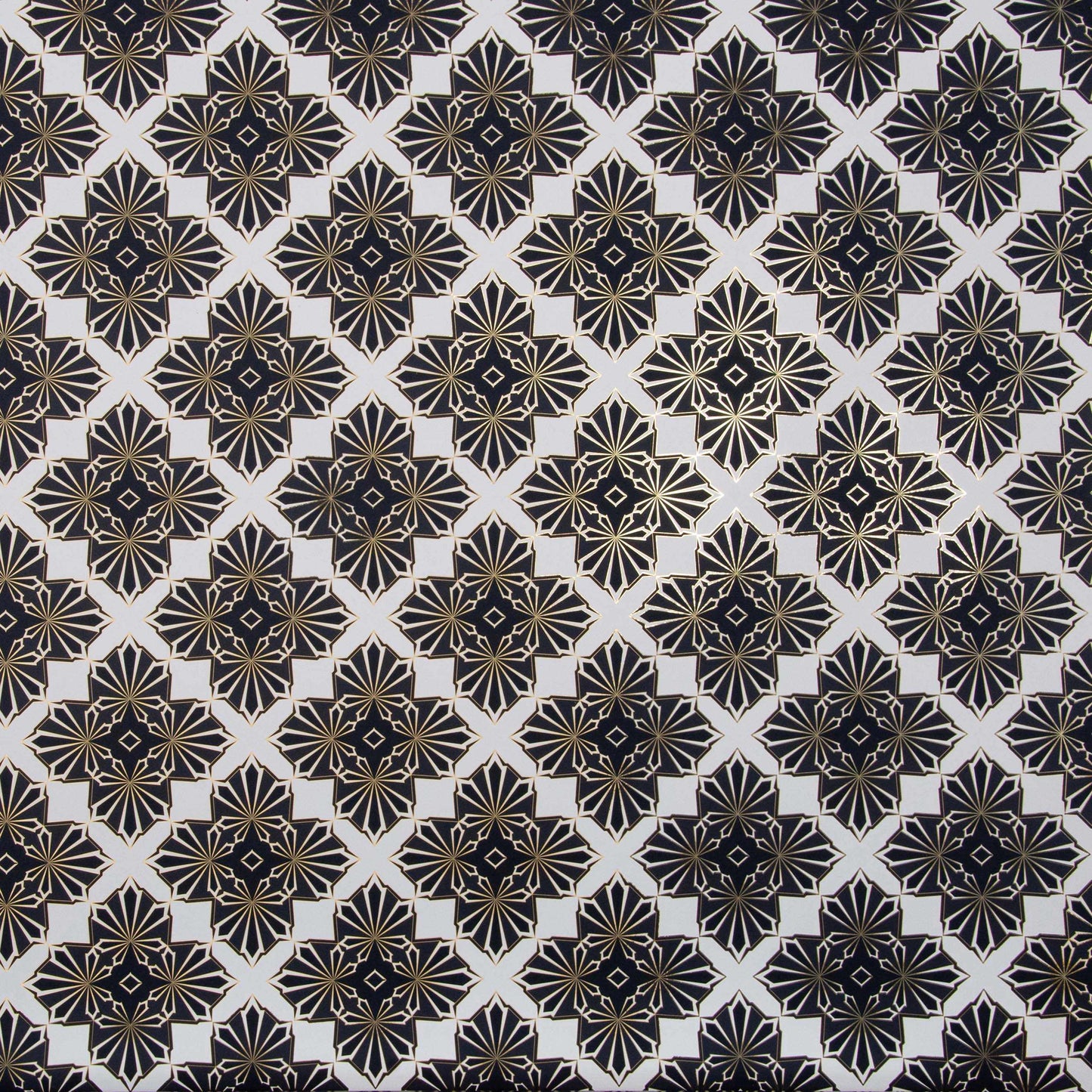 Flat lay of Blaze 'Inhale' wallcovering's geometric pattern in black and gold on a white background.