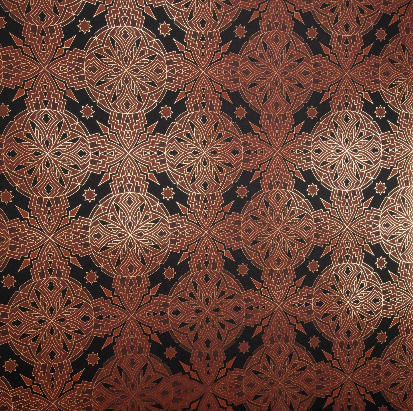 Flat lay of Cha Cha 'Vibe' wallcovering with a complex geometric pattern in copper and gold on a black background.