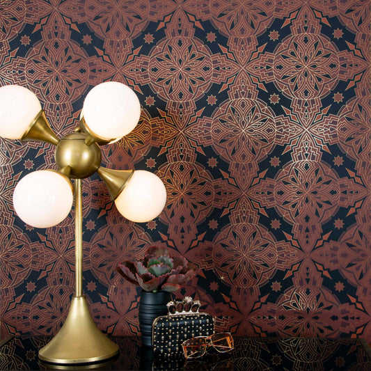 Cha Cha 'Vibe' wallcovering in warm copper tones installed behind a modern brass lamp and styled accessories.