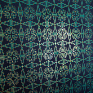 Integratronic Plush is a mid-century retro repeat geometric pattern featuring motifs in various greens on a darkest green background all outlined in gold and digitally printed on gold mylar  - shown here at an angle with light illuminating the gold outlines