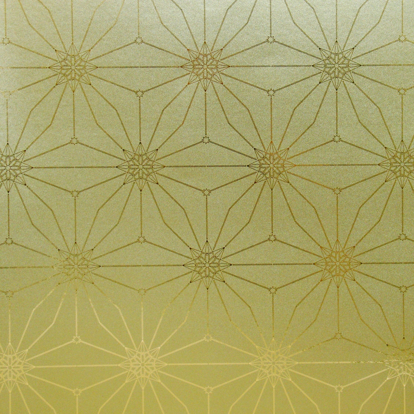 A swatch of Star Guitar 'Dawn' wallcovering with a geometric gold star pattern.