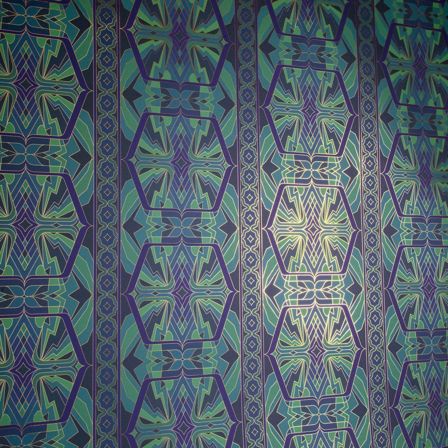 Angled close-up of Sampa 'Undersea' wallpaper in deep blues, greens, and purples with gold details.