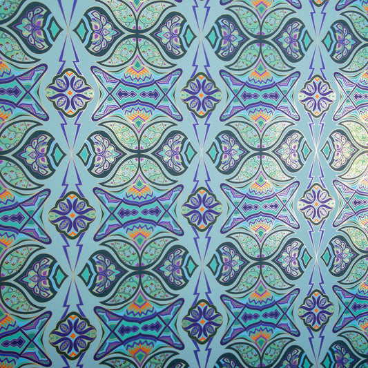 Ulu Garden is a graphic repeat pattern featuring various gold outlined organic motifs geometrically woven together in vibrant blues, greens, and floral colors orange, purples, outlined in gold, digitally printed on gold mylar, and shown at an angle with the light catching the gold