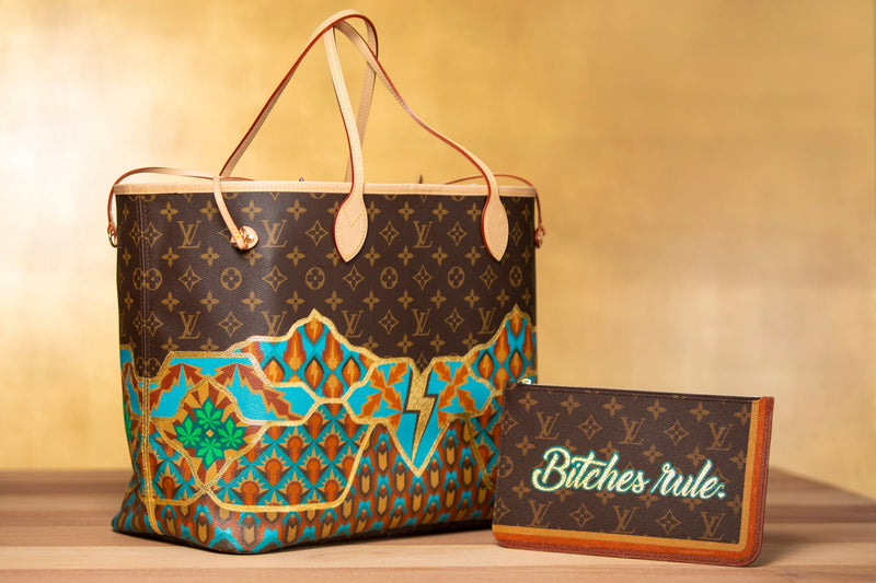 Custom-painted Louis Vuitton tote with a matching pouch that reads 'Bitches rule.'