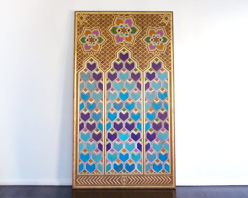 A large, gilded art panel with intricate Moorish geometric patterns in jewel tones of purple and teal.