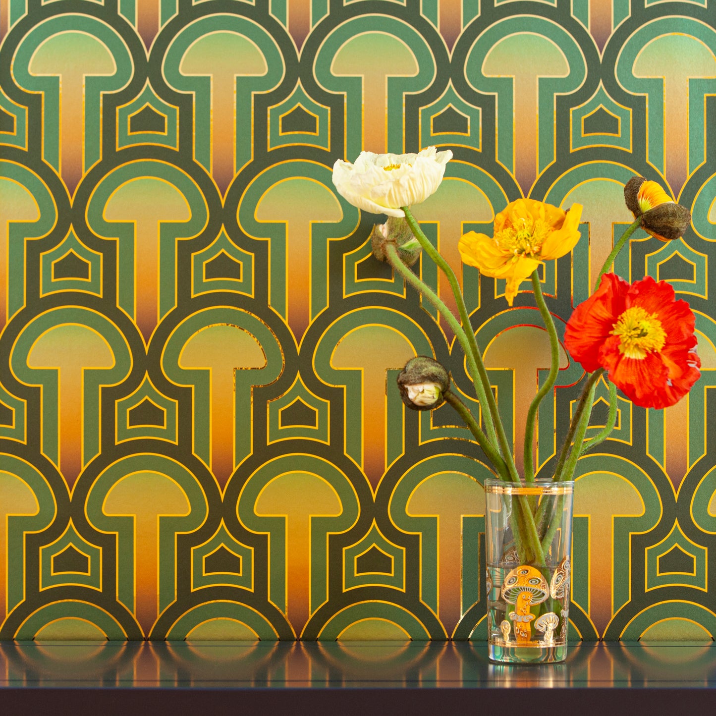 Enlightenment 'Psilocybe' Wallcovering as a backdrop for a clear glass holding colorful poppies.