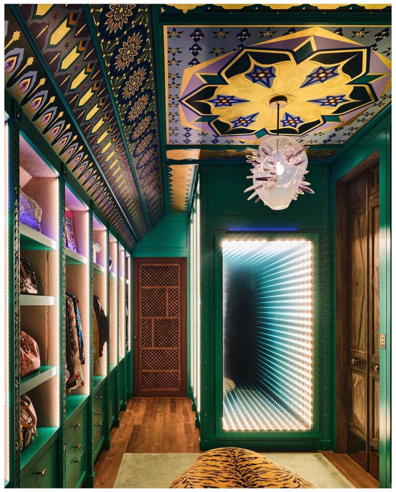 A maximalist walk-in closet with green walls and a custom Moroccan-inspired geometric painted ceiling.