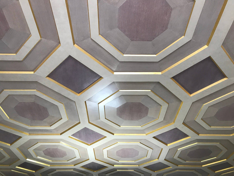 A custom coffered ceiling with a geometric pattern of octagons and squares in mauve and gold.
