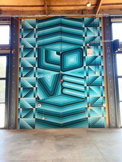 Hand-painted geometric ‘Love’ mural at TOMS Shoes Headquarters by Londubh Studio — large-scale wall art celebrating connection and color.
