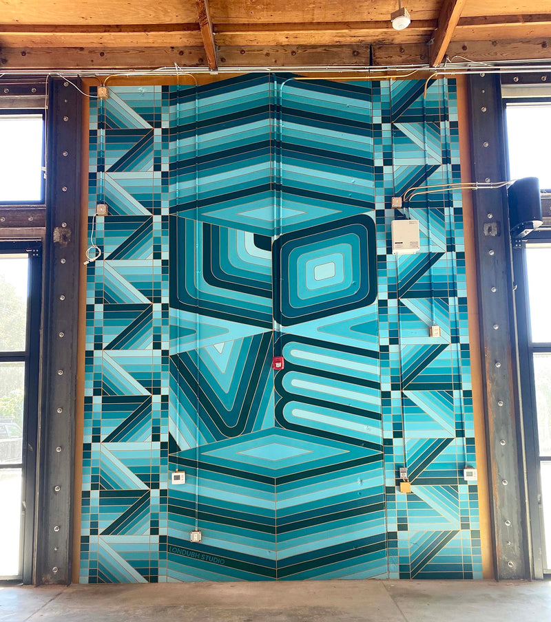 A full view of the large-scale Cha Cha 'Chill' mural in an industrial-style room.