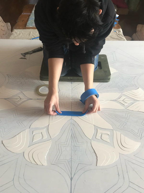 Applying textured plaster base of 4 central panels to ensure they would precisely line up when installed on site.
