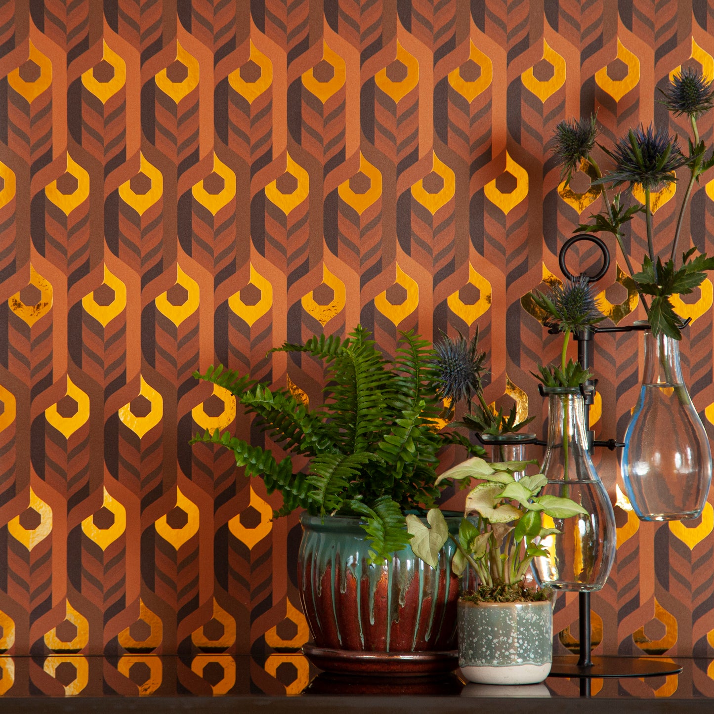 The Integratronic 'Desert' Wallcovering in warm earth tones behind an arrangement of houseplants.