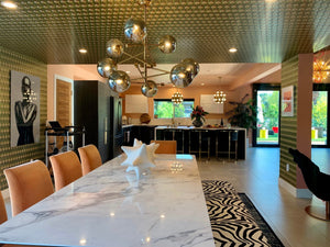 Neowise custom green and gold wallpaper ceiling and wall installation in modern maximalist dining room with neo-modern sputnik chandelier over marble table.
