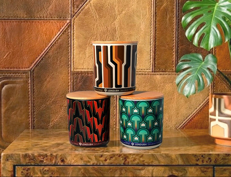 The Londubh Candle Set, featuring three distinct patterns, stacked on a burl wood table.