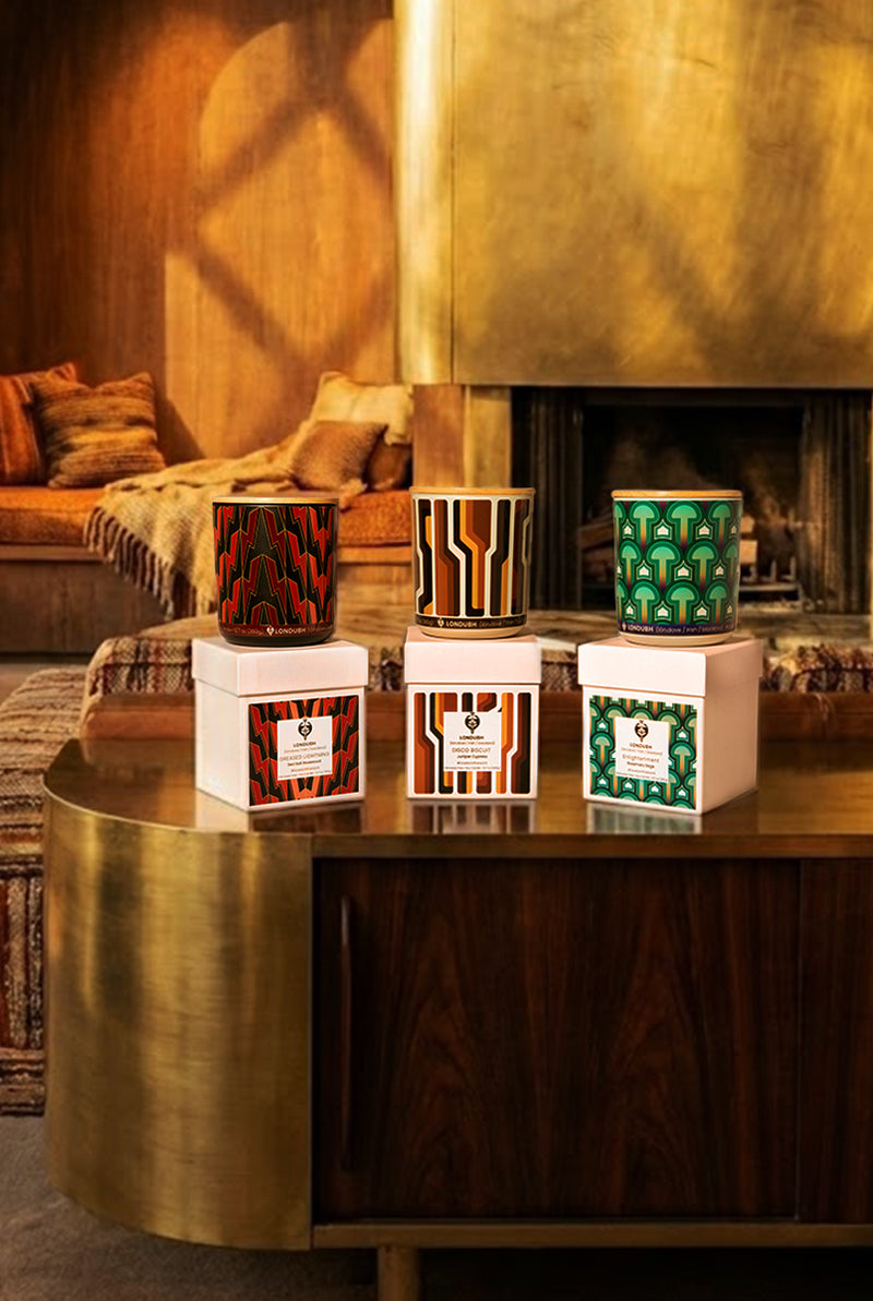 The Londubh Candle Set with their boxes on a modern console table in a warm living room.