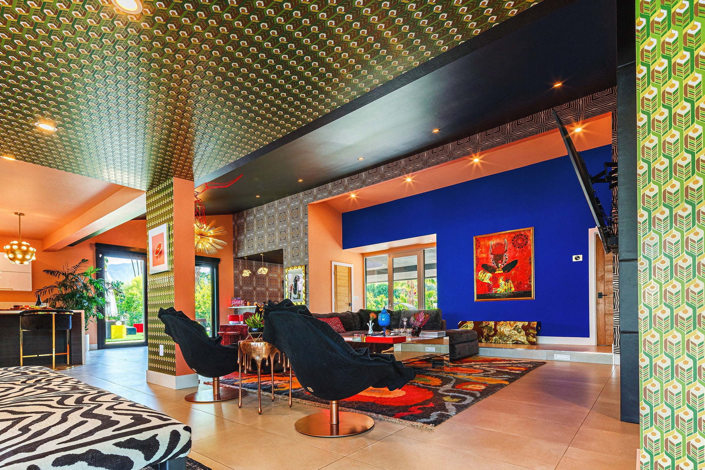 A vibrant living room with a blue wall, black chairs, and a ceiling in Enlightenment 'Psilocybe' Wallcovering.