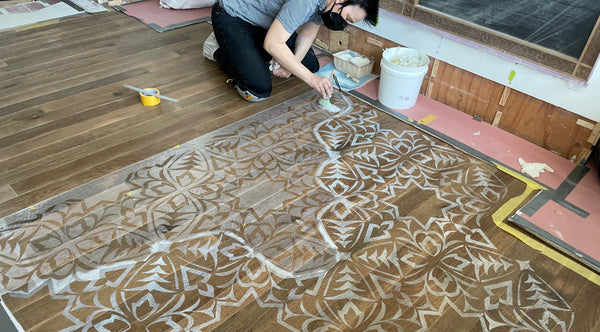 Applying the medium to the wood floor.