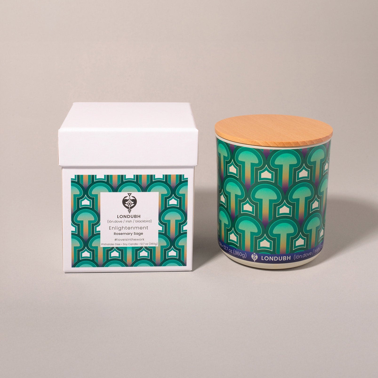 The Enlightenment Candle in the green 'Psilocybe' pattern, sitting next to its matching white gift box.