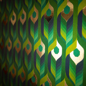 Neowise Tropical is a maximalist colorful repeat pattern wallpaper inspired by a comet that flew over Newgrange in Ireland and looks like a feather motif but is inspired by grain, and is tropical blues and greens, and gold, and printed on gold mylar  - shown here at an angel with light illuminating the gold