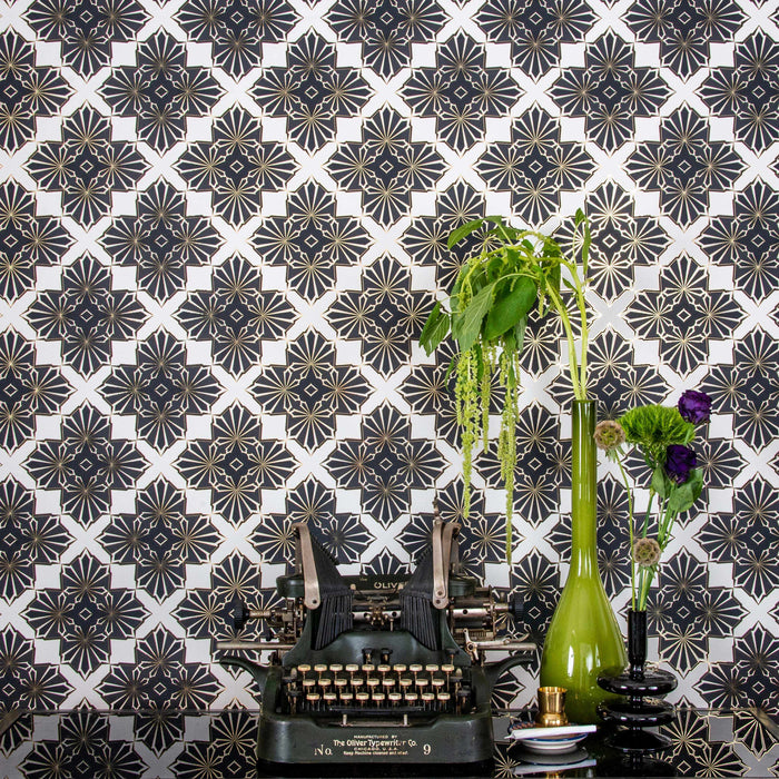 Blaze 'Inhale' wallcovering behind a vintage typewriter and vases with green and purple botanicals.