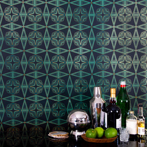 Integratronic Plush is a mid-century retro repeat geometric pattern featuring motifs in various greens on a darkest green background all outlined in gold and digitally printed on gold mylar - shown here with a small bar set up with bottles, limes, a shaker and shot glasses