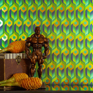 Neowise Tropical is a maximalist colorful repeat pattern wallpaper inspired by a comet that flew over Newgrange in Ireland and looks like a feather motif but is inspired by grain, and is tropical blues and greens, and gold, and printed on gold mylar - shown here in a vignette with a muscleman sculpture, pinecones or seedpods, and a vintage box. 