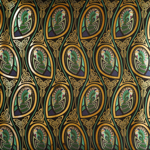 Peacock Nouveau Bejeweled is a Celtic and Art Nouveau inspired maximalist repeat pattern wallpaper featuring peacocks and Celtic knot work in gold, jewel tones, blues, greens, on a black background, outlined in gold and digitally printed on gold mylar 